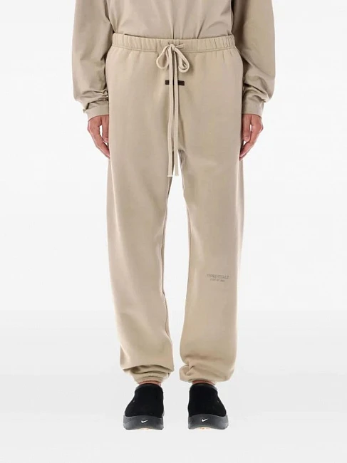 картинка Fear of God Essentials Fleece Sweatpant Timber магазин Одежда+ являющийся официальным дистрибьютором в России 