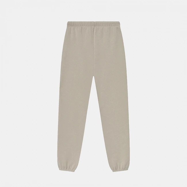 картинка Fear of God Essentials Fleece Sweatpant Timber магазин Одежда+ являющийся официальным дистрибьютором в России 